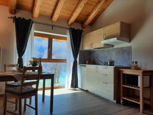 uma cozinha com uma mesa e uma mesa e uma janela em Ai Monti em Barcis