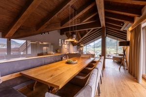 a dining room with a wooden table and chairs at Bergresort Zugspitze Ehrwald by ALPS RESORTS in Ehrwald