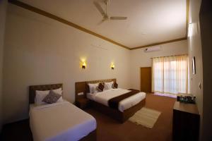 ein Hotelzimmer mit 2 Betten und einem Fenster in der Unterkunft The Vanashva in Tehla