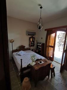 a bedroom with a bed and a table and a window at Mike's Cycladic Villa in Poros