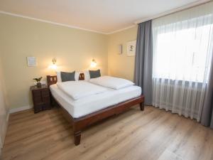 a bedroom with a bed and a large window at Hotel Altmünchen by Blattl in Munich