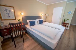 1 dormitorio con 1 cama blanca grande y escritorio en Hotel Altmünchen by Blattl, en Múnich