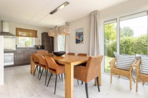 a kitchen and dining room with a wooden table and chairs at Summio Vakantiepark It Wiid in Earnewâld