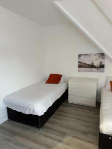 a white bedroom with a bed and a couch at Stunning 2-Bed Apartment in Chelmsford in Chelmsford