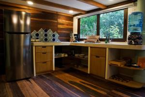 eine Küche mit einem Kühlschrank aus Edelstahl und einem Fenster in der Unterkunft Cabaña Chechen, wooden chalet in tropical garden in Isla Mujeres