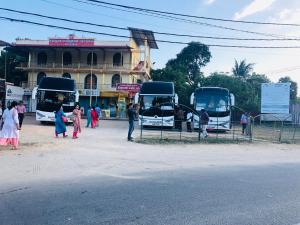 zwei Busse, die vor einem Gebäude geparkt sind in der Unterkunft Nallur Mylooran Arangam in Jaffna