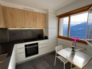 a kitchen with a table and a view of mountains at The Fit’ house in Crans-Montana