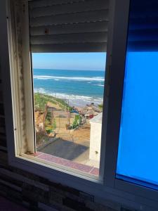 a window view of the ocean from a house at Ocean View Room in Asilah