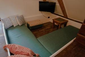 a small living room with a couch and a tv at Cabaña Chechen, wooden chalet in tropical garden in Isla Mujeres