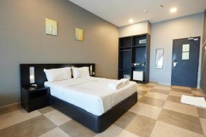 麻坡Elite Hotel Muar的一间卧室配有一张带白色床单的大床