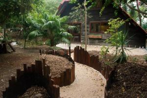 una valla de madera frente a una casa en Cabaña Chechen, wooden chalet in tropical garden en Isla Mujeres