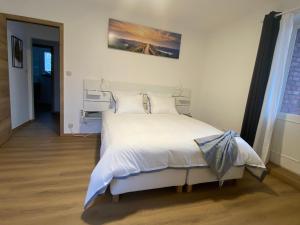 a bedroom with a large bed with white sheets and pillows at D-012 Bel appart et balcon climatisé parking privé gratuit sur demande in Charleroi