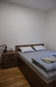 - une chambre avec un lit doté d'un cadre de lit en bois dans l'établissement Apartman Irvas Zlatibor, à Zlatibor