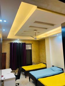 a room with two beds and a ceiling at StayHolic in Ghaziabad