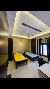 una camera con due letti e un divano in esso di StayHolic a Ghaziabad