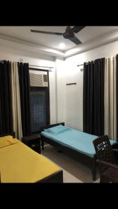 Camera con letto e ventilatore a soffitto. di StayHolic a Ghaziabad