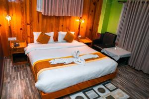 Cette chambre d'hôtel dispose d'un grand lit avec des animaux farcis. dans l'établissement Hotel Kamana, à Pokhara