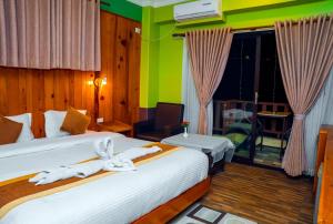 - une chambre avec un lit et des serviettes dans l'établissement Hotel Kamana, à Pokhara