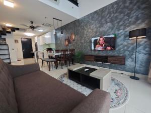 a living room with a couch and a tv on a wall at Centrus Soho Cyberjaya by IdealHub in Cyberjaya