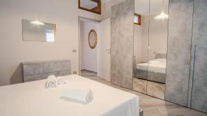 een witte kamer met een bed en een spiegel bij La Bella Galeazzi - Italian Homing in Sirmione