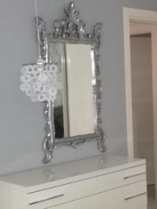 a mirror sitting on top of a dresser at Fiumicino Aeroporto Casa Vacanze Papaveri in Fiumicino