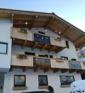 a building with a deck with potted plants on it at Gemütliche Wohnung 10 Minuten vom See entfernt in Zell am See