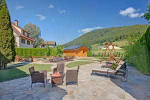 a patio with chairs and a park with a playground at Ferienhotel Ödenhof in Baiersbronn