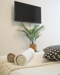 uma televisão numa parede acima de uma cama com toalhas em Padova Lux Station em Pádua