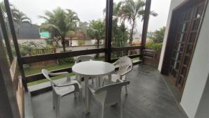 einen Tisch und Stühle auf einem Balkon mit Aussicht in der Unterkunft Casanapraia Bertioga in Bertioga