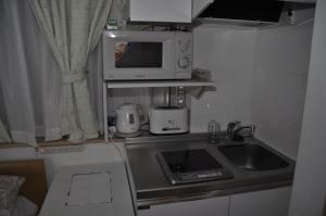 a kitchen with a sink and a microwave at Sunny moe oo in Tokyo +6 photos