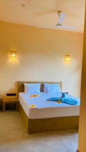 a bedroom with a bed with blue sheets and pillows at Ayubowan Hiriketiya in Dickwella