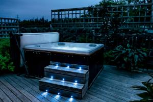 a bath tub sitting on a deck with lights at Mountainstudios Beudy Bach & Beudy Mawr in Bangor