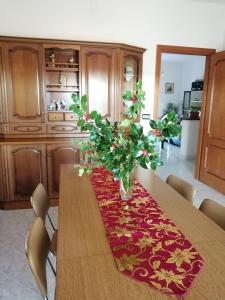 - une table à manger avec un vase de fleurs dans l'établissement L Agrifoglio di Rita Loddo, à Fonni