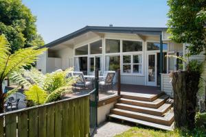 a home with a screened porch and stairs to a house at Pool House- Springfield in Rotorua