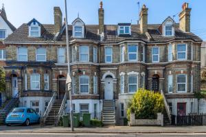 KentFolkestone Ramblers Rest的前面有一辆蓝色汽车的房屋