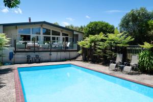 a swimming pool in front of a house at Pool House- Springfield in Rotorua