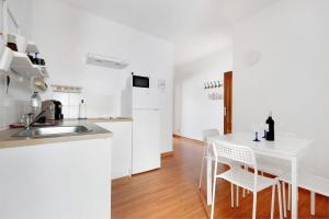 a kitchen and dining room with a white table and chairs at Apartamento Aka in La Orotava +13 photos