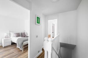 a white bedroom with a bed and a staircase at Spacious Free Parking Contractors and Corporate in Exeter