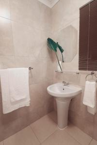 a white bathroom with a sink and a mirror at Fair Haven Guest Suite Self-catering in Marina Beach