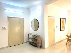 um quarto branco com um espelho e uma porta em Appartement - Le Grège em Ouagadougou