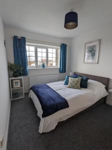 1 dormitorio con 1 cama grande y cortinas azules en The Upper Hymnary, en Roch