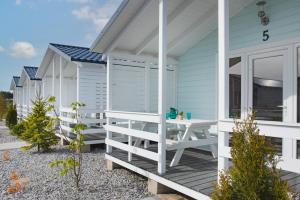una casa sulla spiaggia con terrazza e tavolo di TURKUSOWE ZACISZE a Kopań