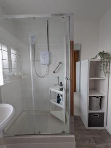 a white bathroom with a shower and a sink at The Upper Hymnary in Haverfordwest +41 photos