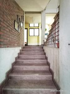 un escalier dans un bâtiment avec un mur en briques dans l'établissement Bhargav Residency , Guwahati, à Guwahati