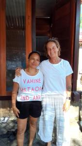 two women standing next to each other holding a sign at Naca Homestay in Manado