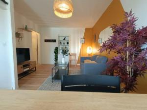 a living room with a couch and a tv at Le Yellow Corner - Place Ney in Angers