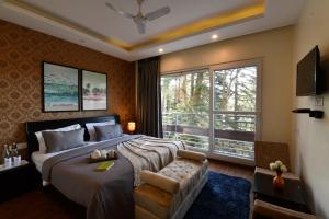 PerfectStayz Shimla في شيملا: غرفة نوم بسرير كبير ونافذة كبيرة
