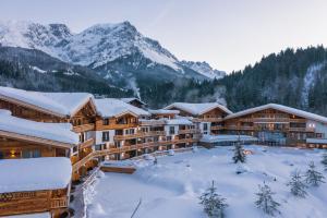 a resort with snow covered mountains in the background at Kaiserlodge in Scheffau am Wilden Kaiser