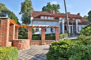 une maison avec une arche en briques devant elle dans l'établissement Ašmonienės svečių namai "Senoji mokyklėlė", à Smalininkai