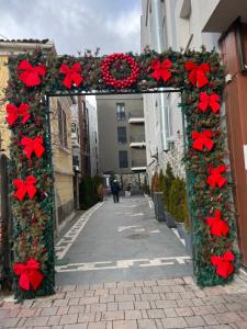 un arco decorado con adornos navideños en una calle en Alma Rose Apartment, en Korçë